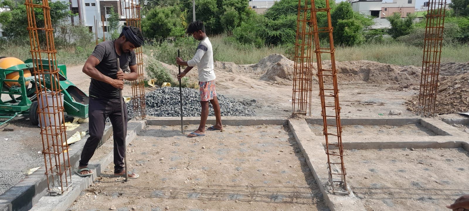 Workers marking column positions on the compacted foundation bed