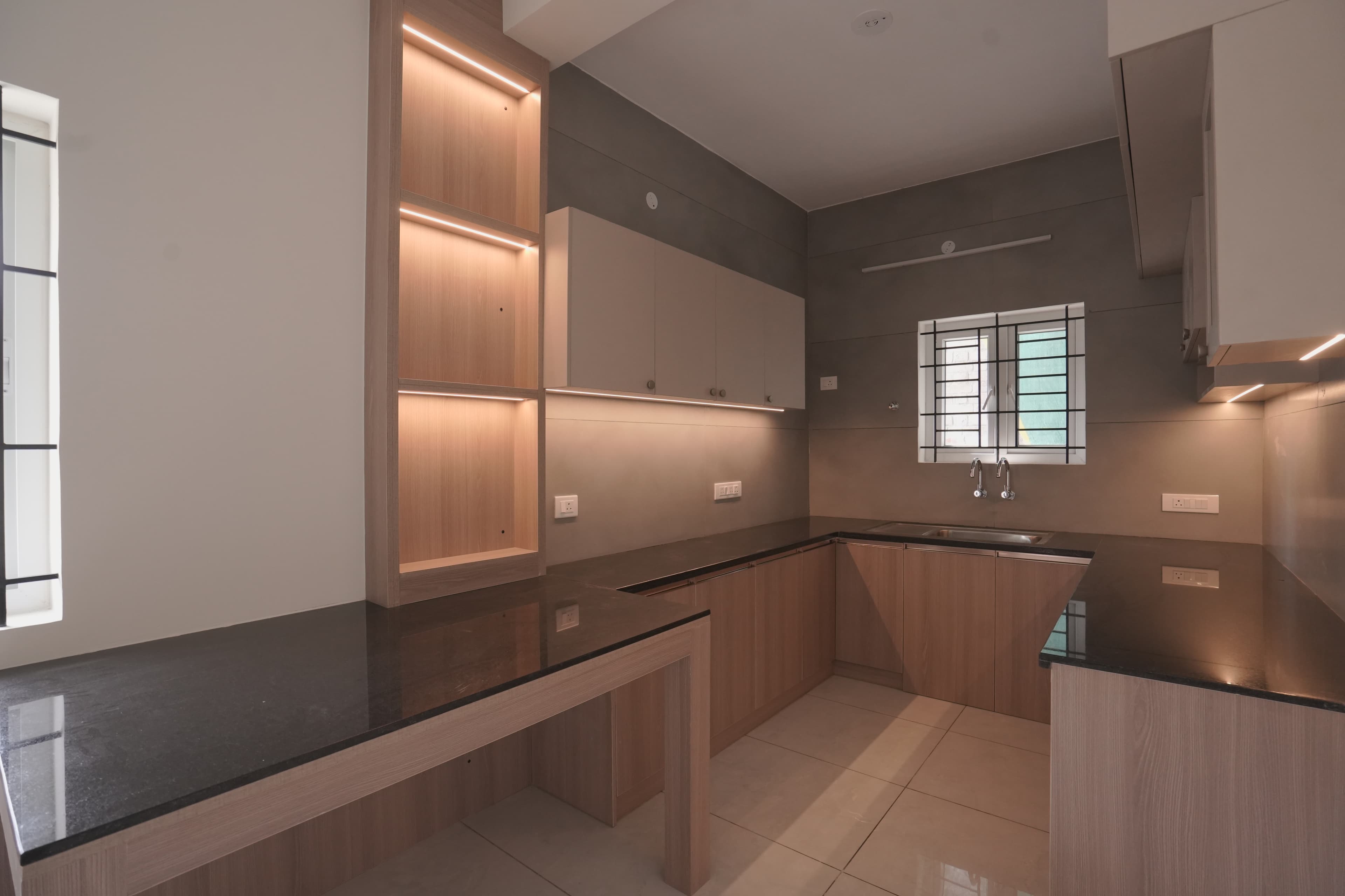 Kitchen with timber cabinetry, black granite counters and lit open shelving