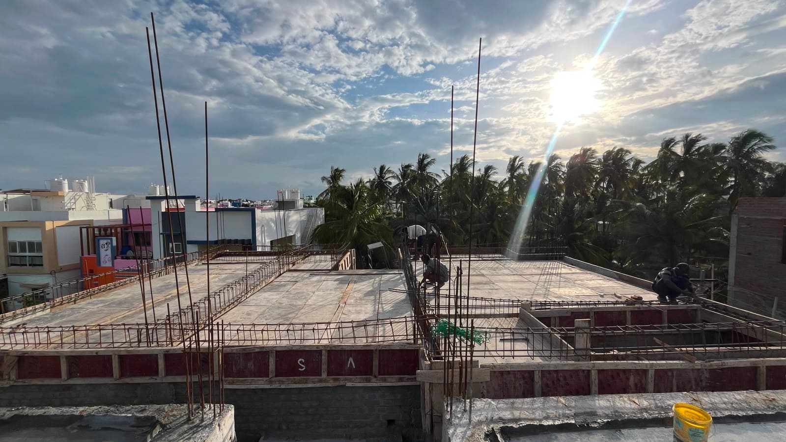Roof slab reinforcement laid out at sunset, workers at the edge