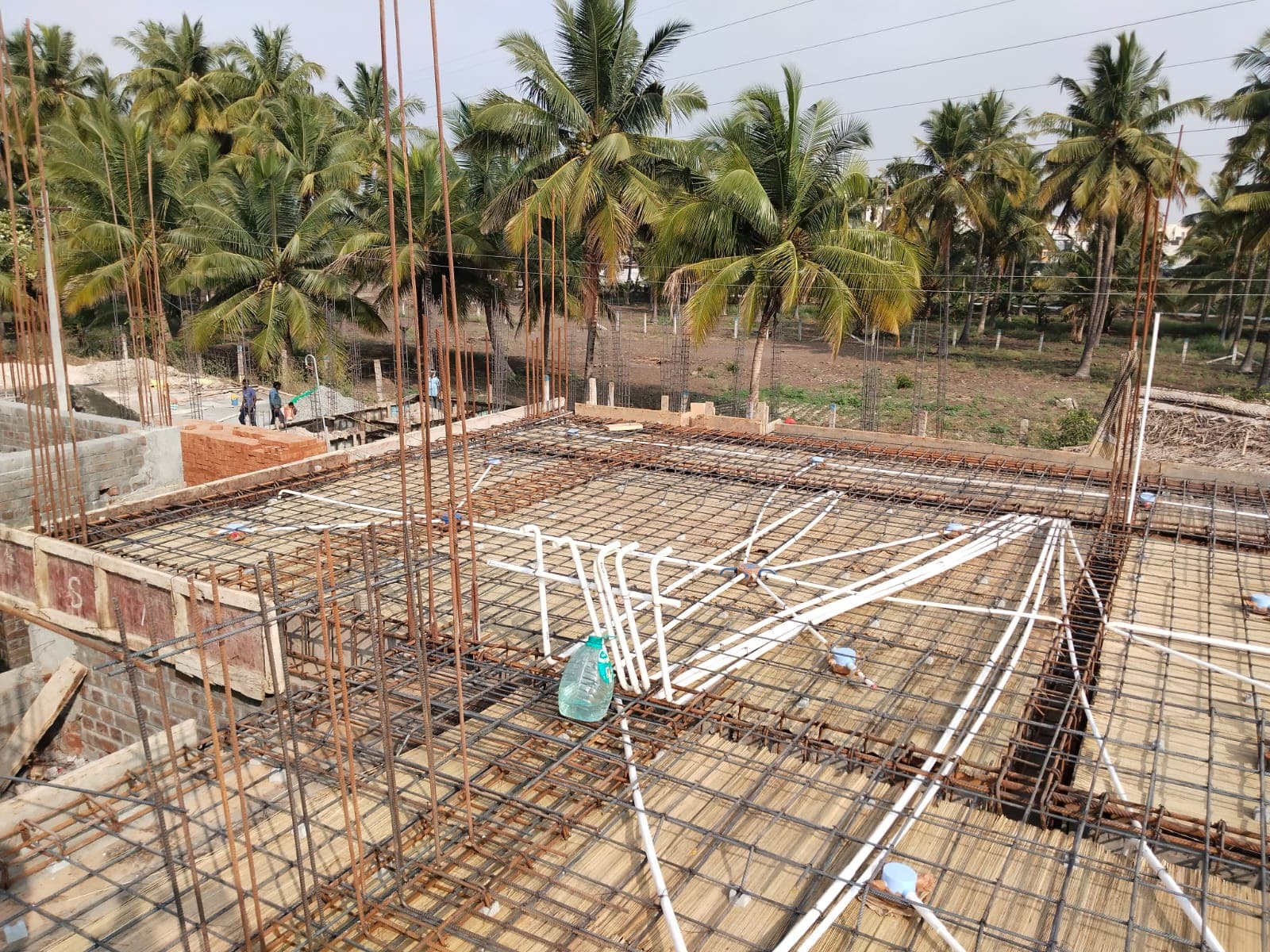 Slab reinforcement with white conduit pipes laid across the mesh before the pour