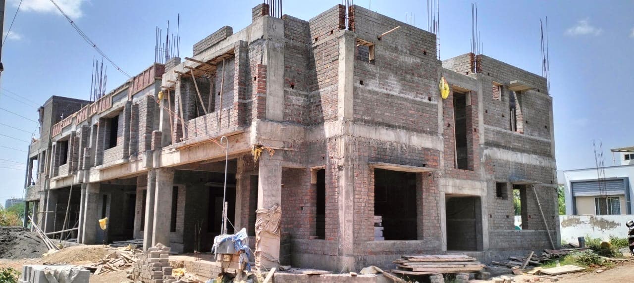 Two-storey concrete frame with brick infill, seen from the street